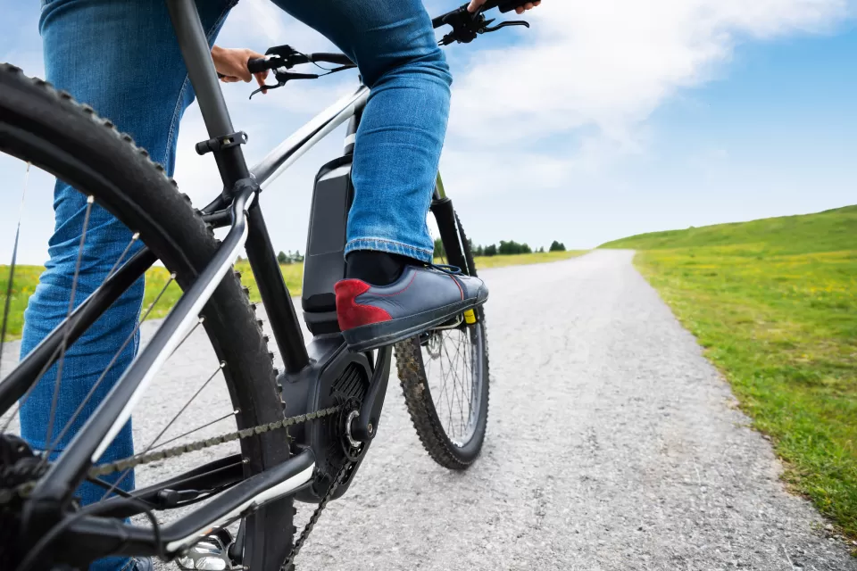 Close-up of person on electric mountain bike on gravel path
